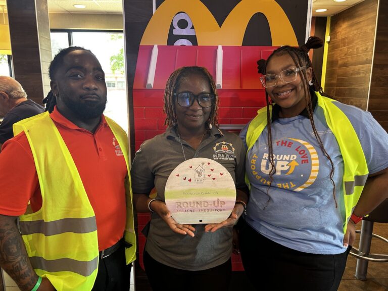 Three McDonald's team members smiling together in a restaurant